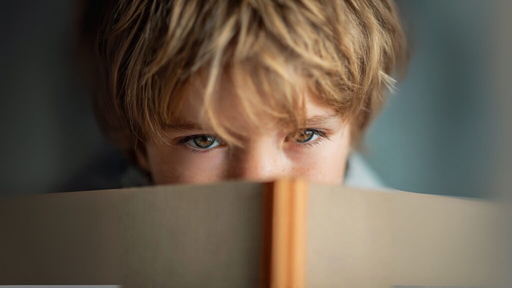 Child showing symptoms of Childhood Myopia while reading up close